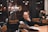 A cheerful group of people reading news articles together in a cozy cafe.
