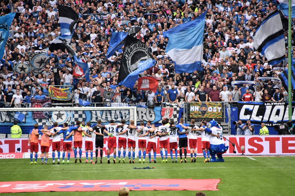 a group of men standing on top of a soccer field