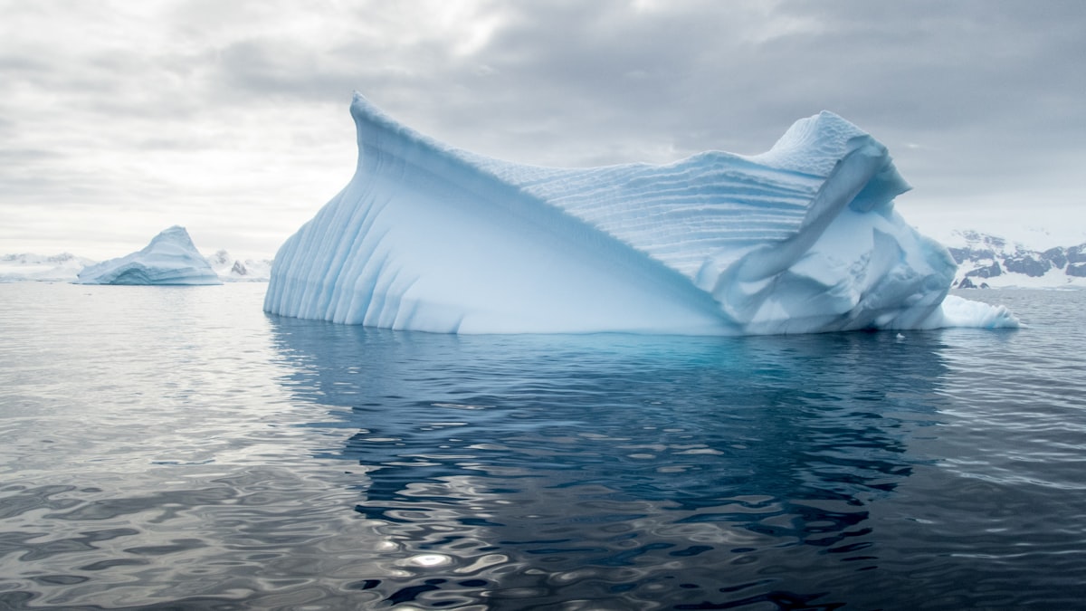 A glacier in Antarctica with deep blue ice meeting the dark water of the Southern Ocean