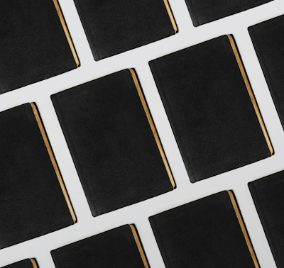 Close-up of an elegant black and gold law book beside neatly stacked legal documents.