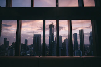 A minimalist skyline at sunset with warm beige and subtle bronze accents.