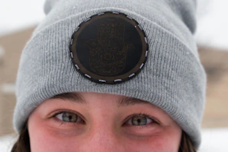 Close-up shot of stylish hats and beanies embroidered with cryptocurrency logos.