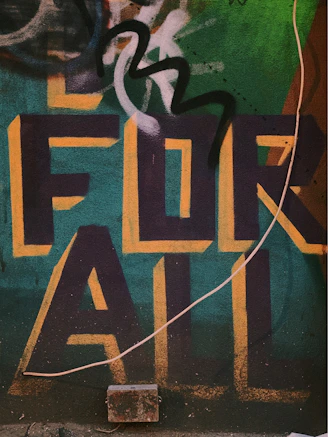 graffitied wall saying for all