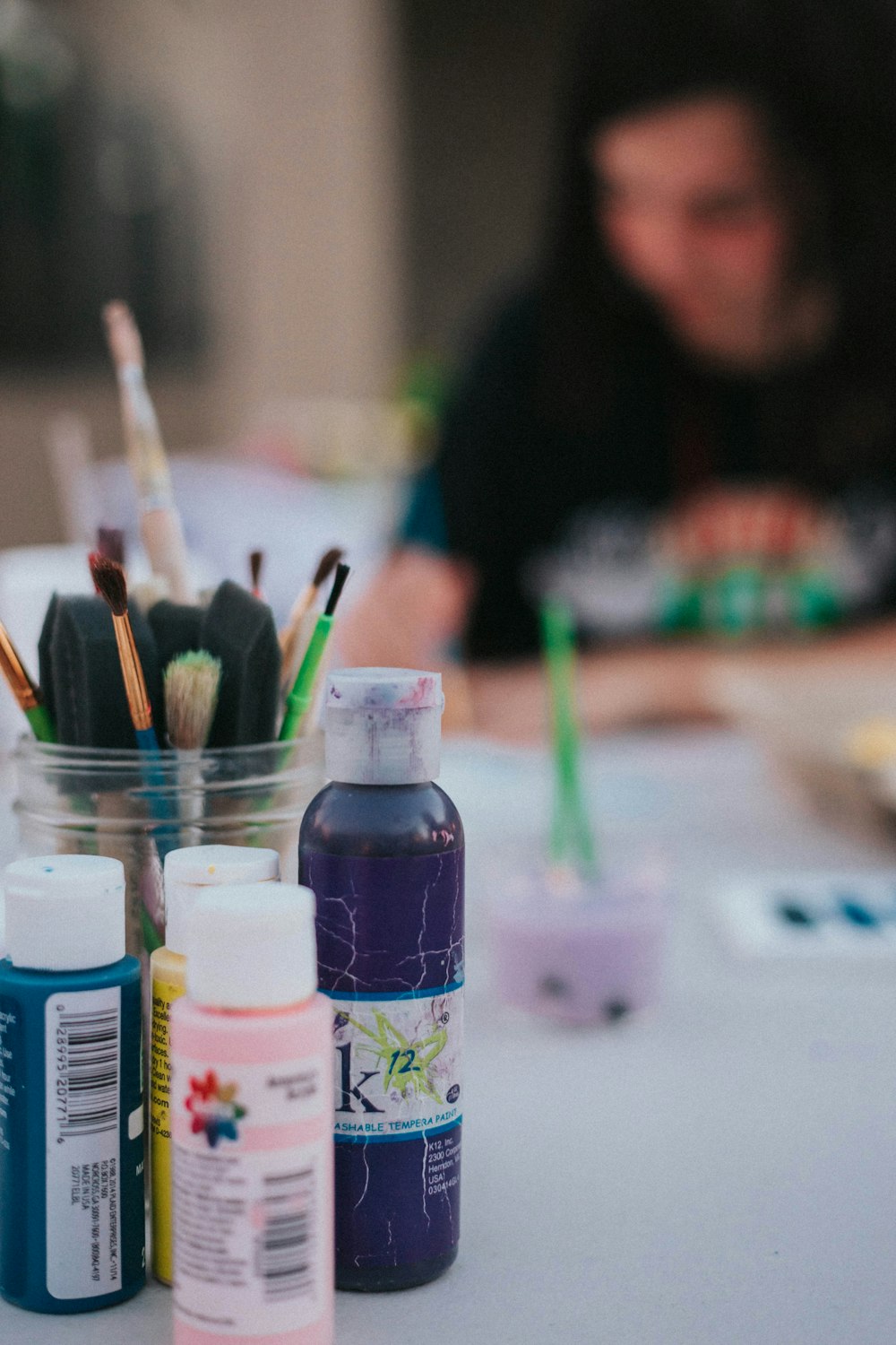 four color bottles near paint brushes