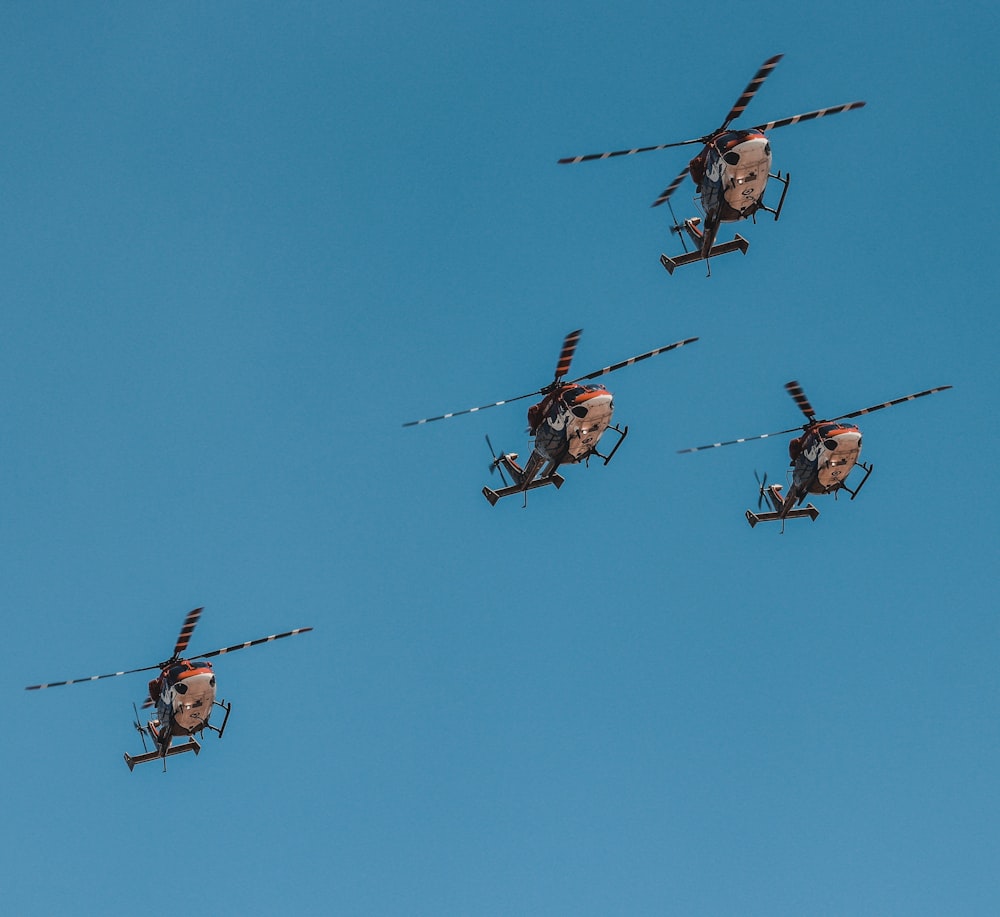 four helicopters flying