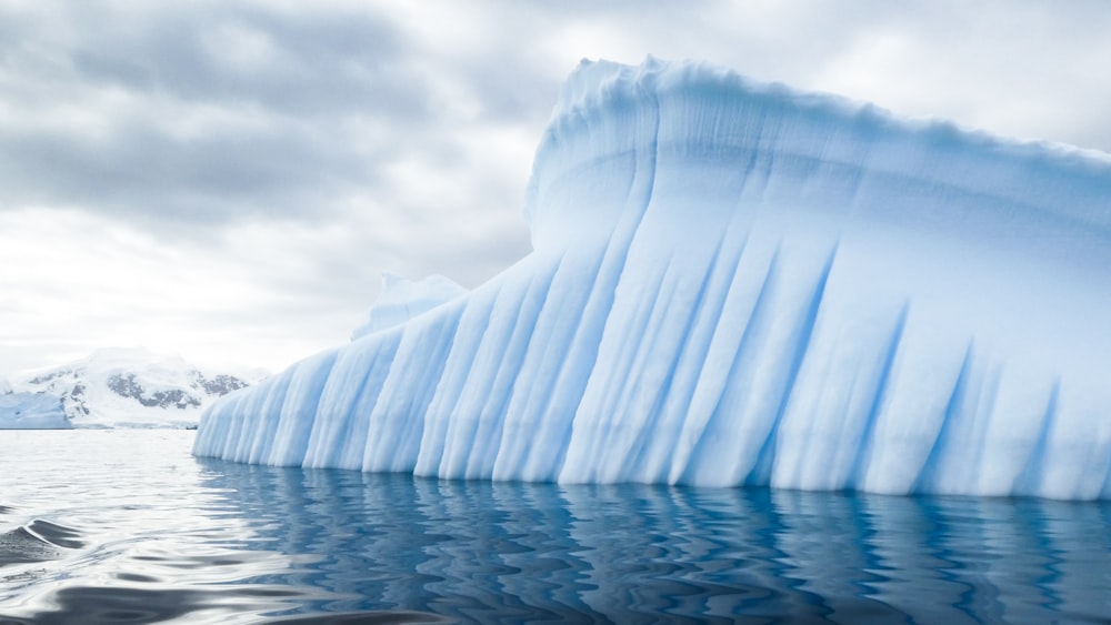 iceberg near mountain during day