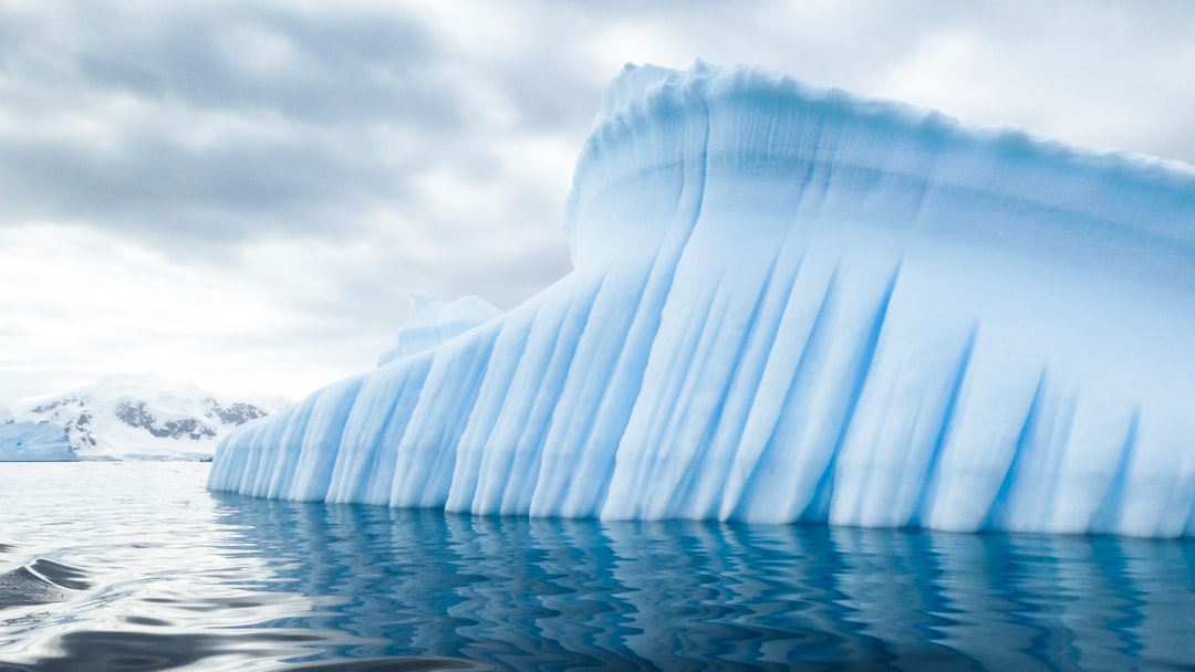 iceberg near mountain during day