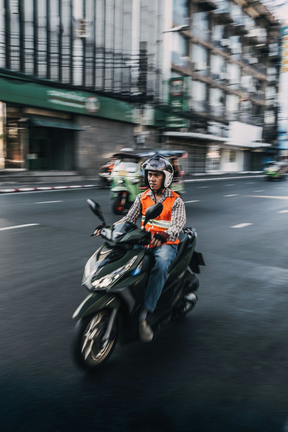 man driving scooter motorcycle during daytime