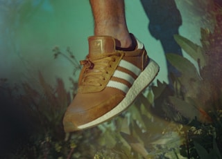 person wearing brown adidas shoe