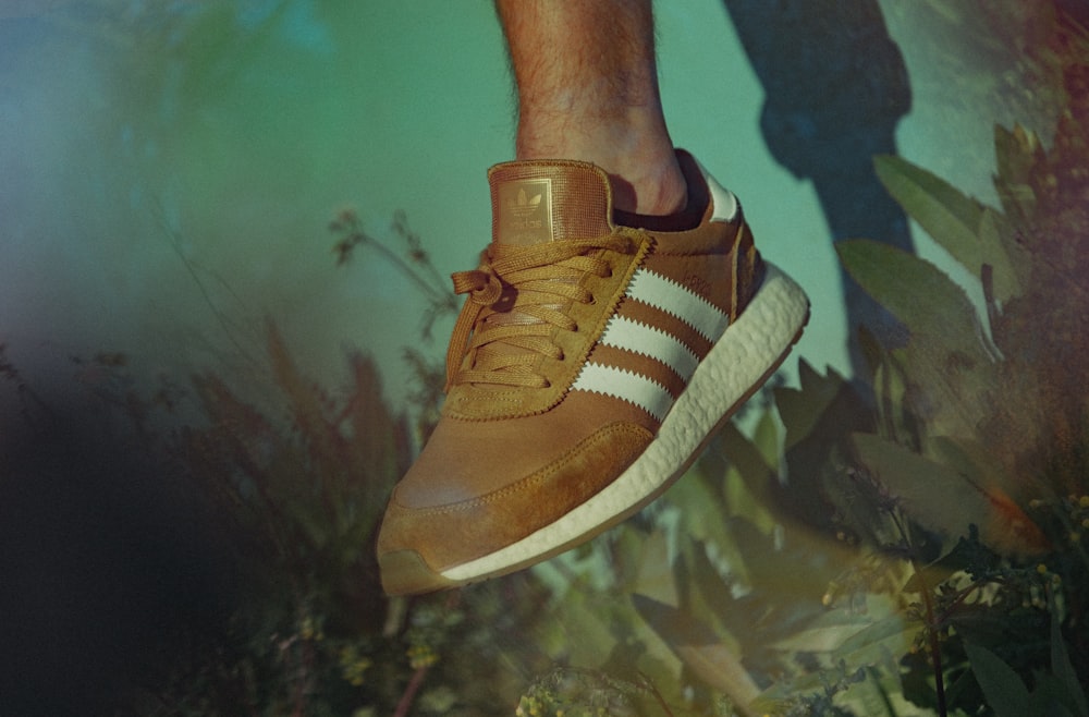 person wearing brown adidas shoe