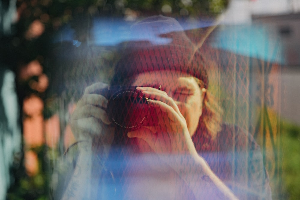 a woman taking a picture through a window