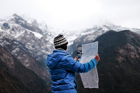 A traveler consulting a map with a scenic mountain background.