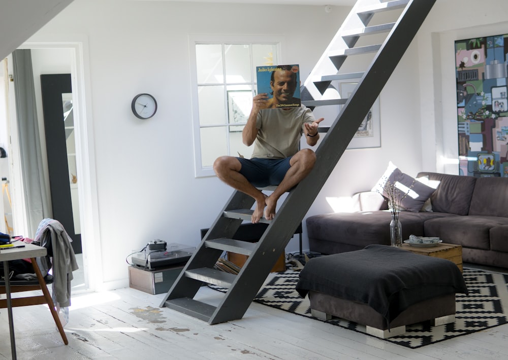 man sitting on ladder inside room