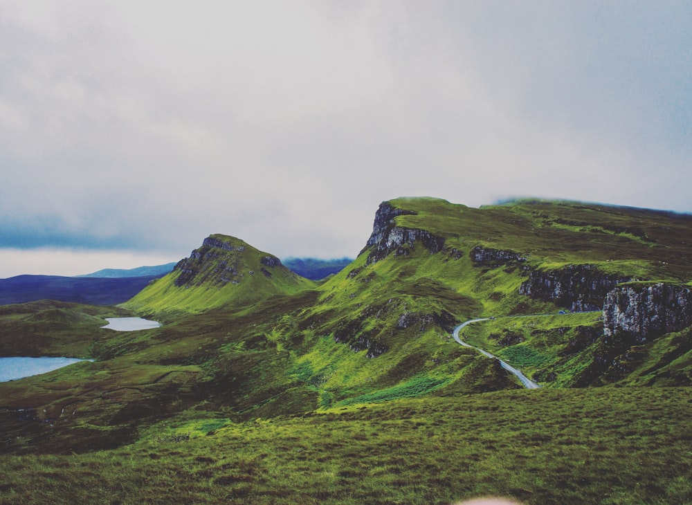 green mountains under a cloudy sky during daytime