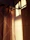 Thermal curtain brackets holding elegant curtains in a sunlit room with soft shadows.