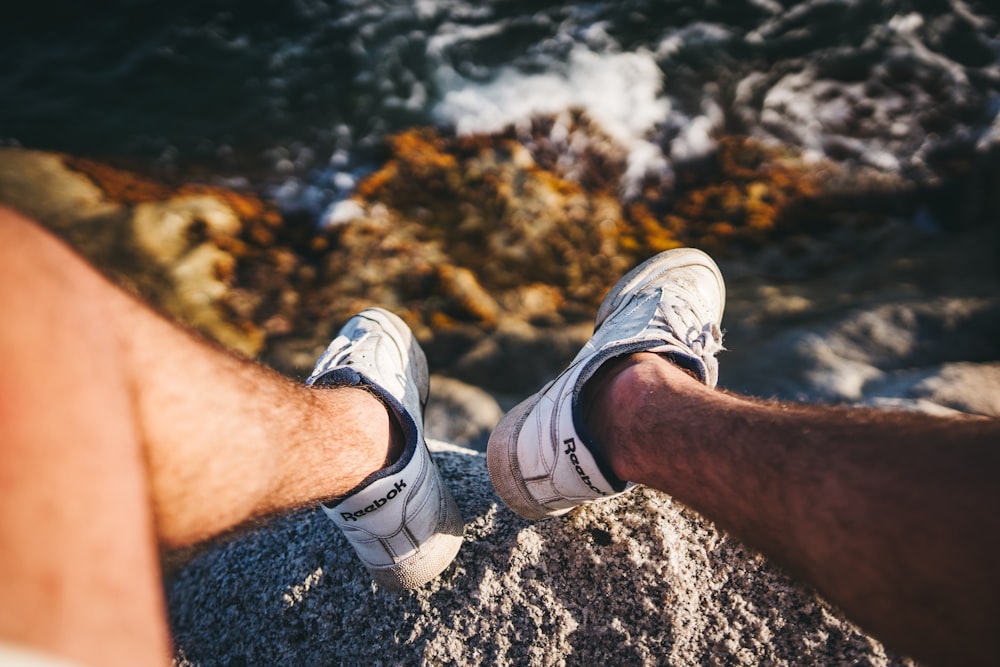 person stepping on gray rock formation