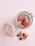 Close-up of a hand holding a glass jar filled with chia pudding topped with fresh berries.