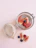 Close-up of a hand holding a glass jar filled with chia pudding topped with fresh berries.