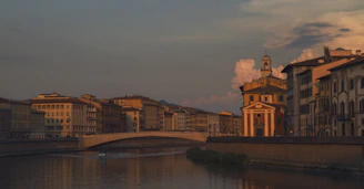 A serene view of Prague's skyline at sunset with the Vltava River reflecting the city lights.