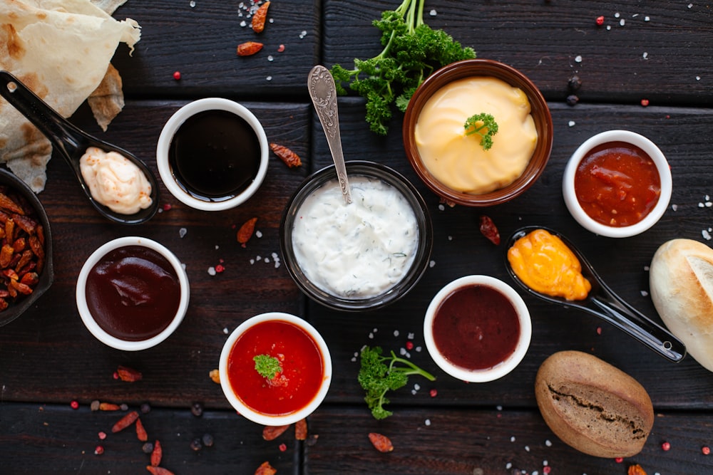 assorted spices on bowls on black wooden surface