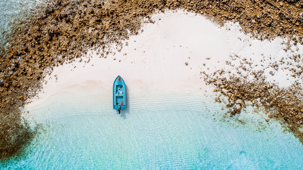 aerial photography of blue boat on seashore