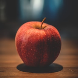 red apple on brown surface