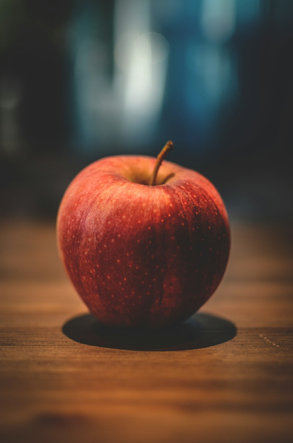 red apple on brown surface