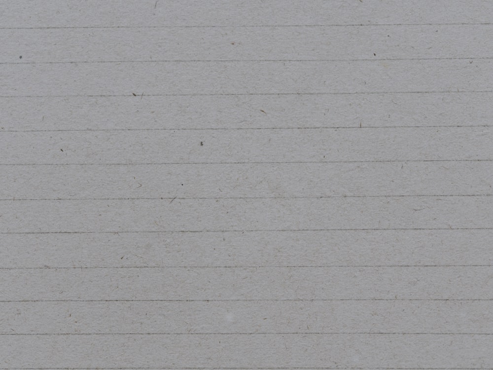 a black and white cat sitting on a piece of lined paper