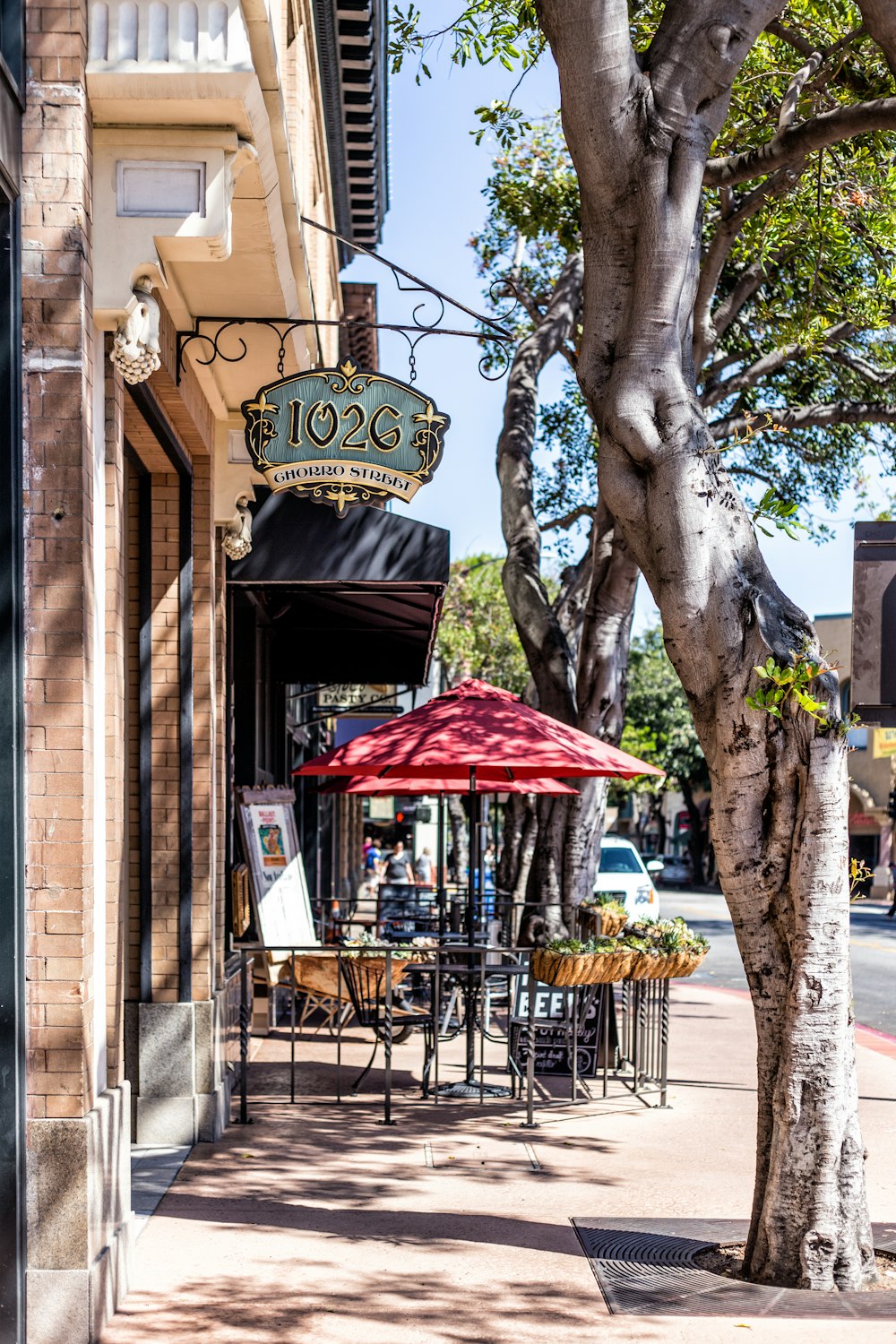 red patio umbrella with table on street