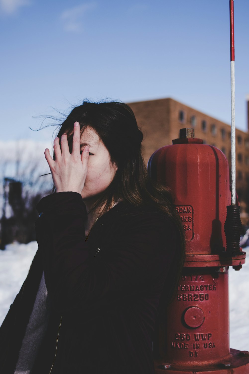 Mujer apoyada al lado de la boca de incendios roja