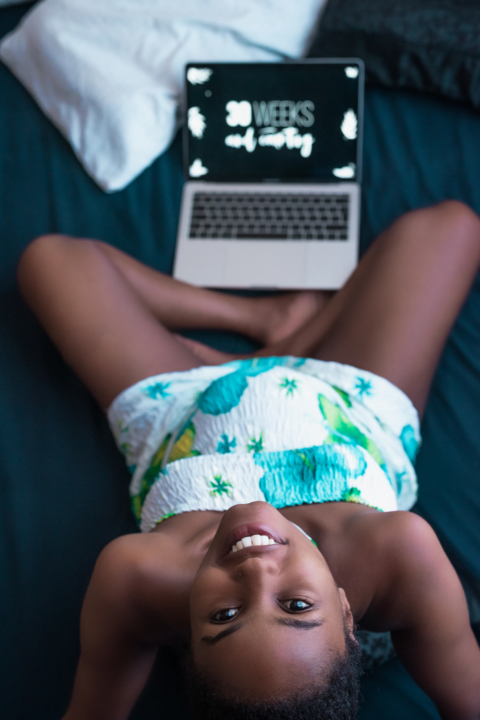 Expectant mother resting with a laptop