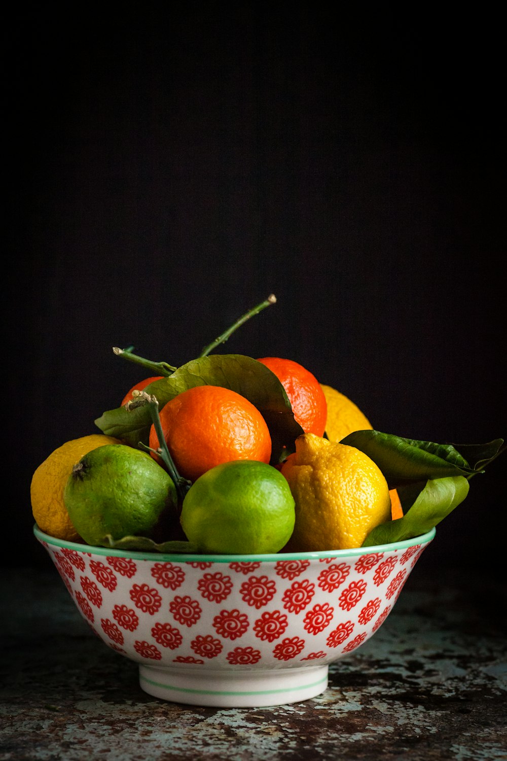 orange and green fruits on bowl