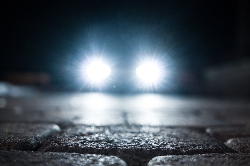 turned-on vehicle headlight on the street