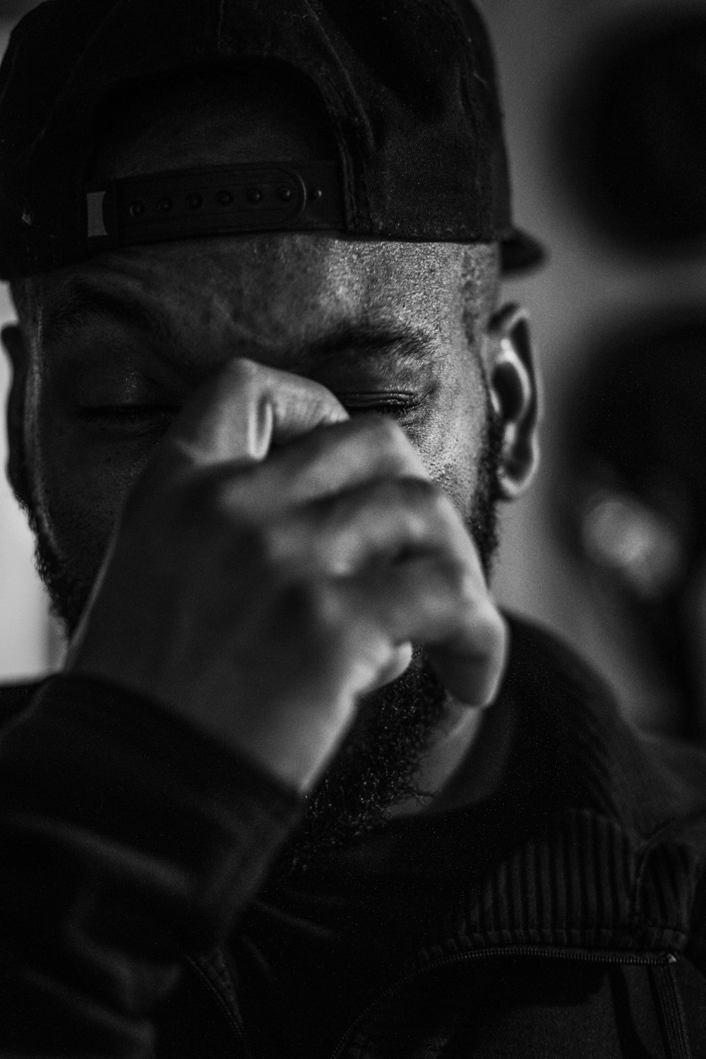 grayscale photo of man in black snapback hat