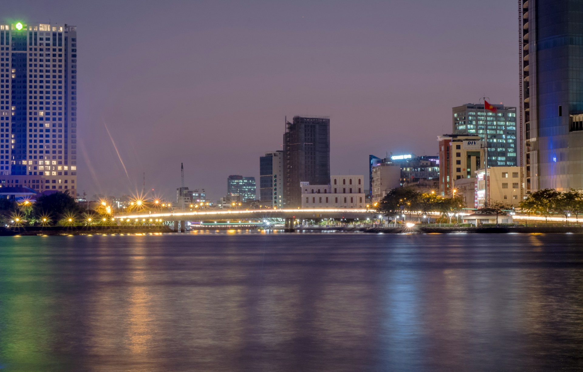 A serene urban nightscape bathed in soft, flowing dynamic light patterns that gently ripple across modern architecture.