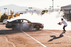 person riding on gray coupe doing drifting