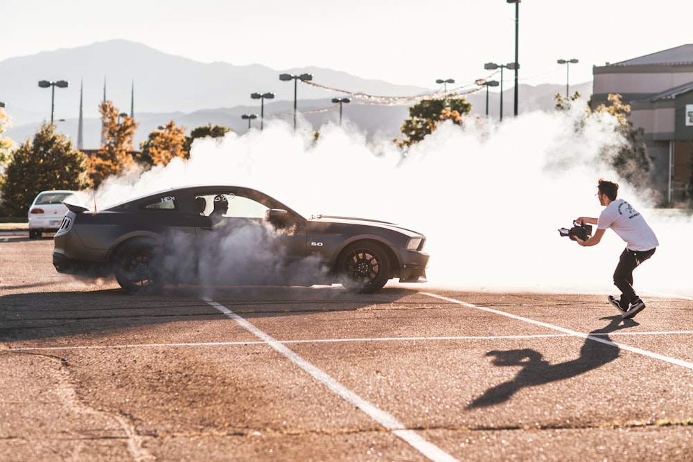 person riding on gray coupe doing drifting