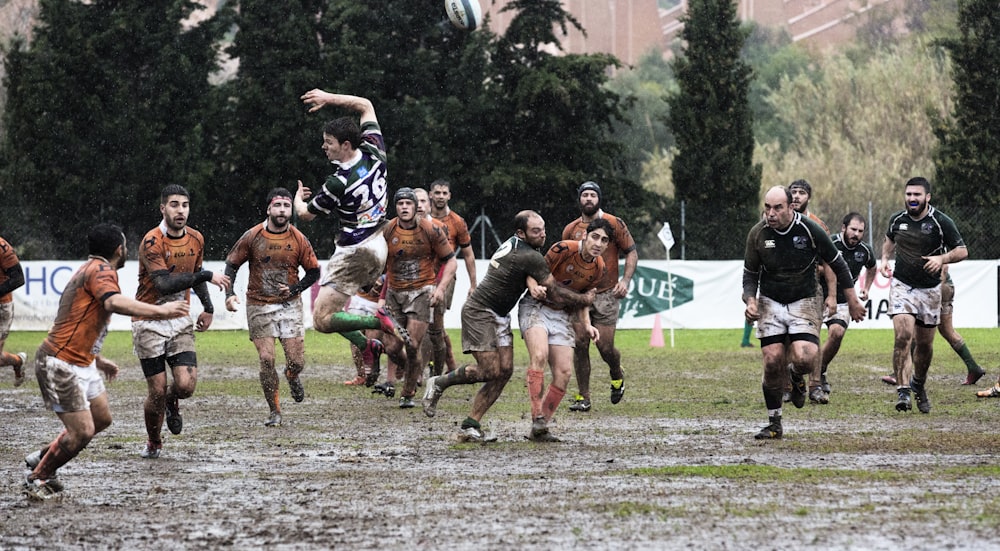 person wearing black jersey jumps across people wearing orange jerseys