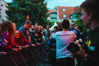 man holding black DSLR camera standing on street