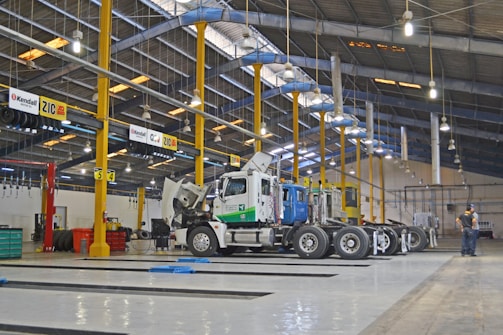 A technician inspecting a heavy-duty truck engine in a well-lit garage.