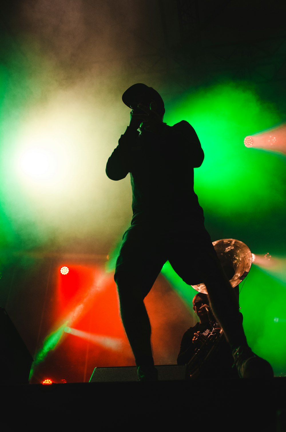 silhouette of man holding microphone standing on stage