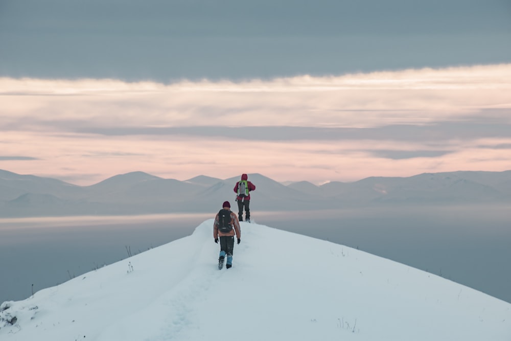 two person standing on snow covered mountain