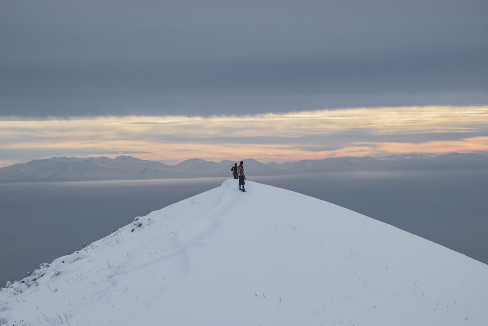 two person standing on white snow