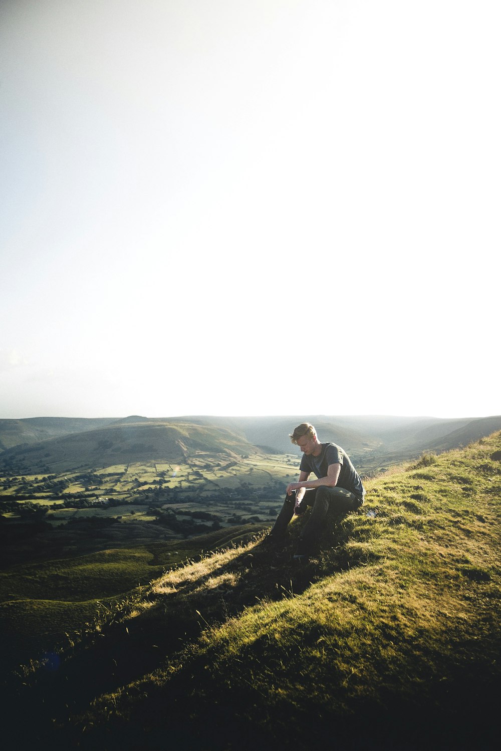 man sitting on green grass ground