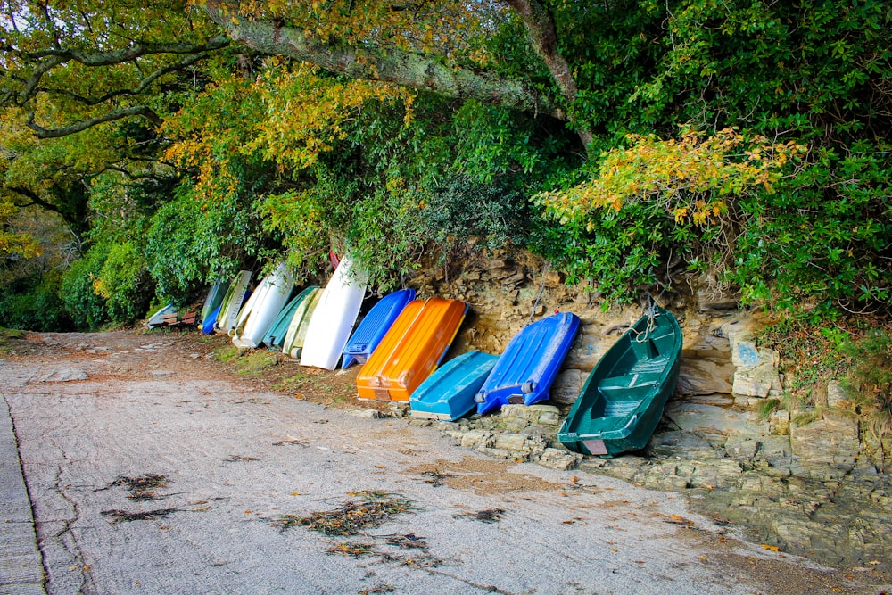 boats leaning beside rocks and trees