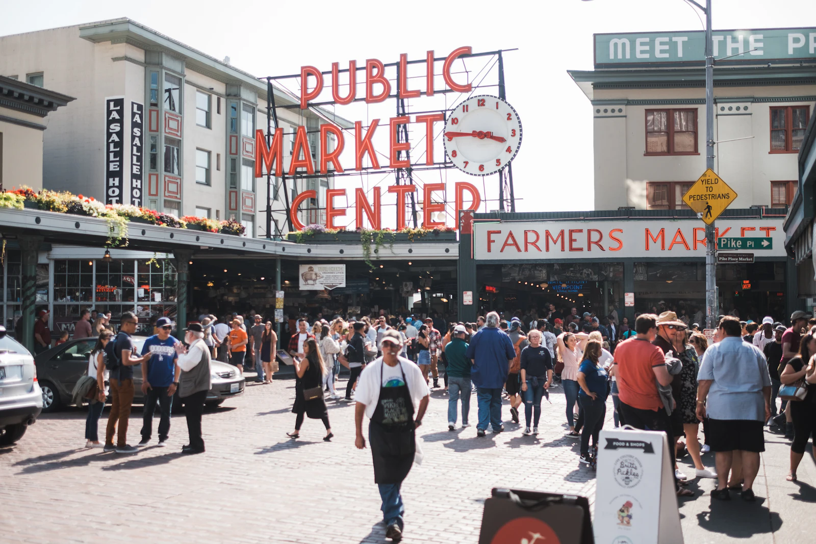 Busy public market entrance with tourists walking on a sunny day