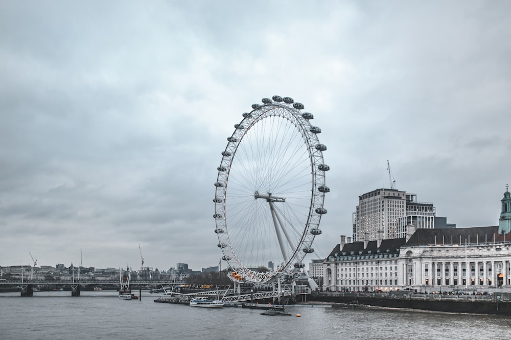 Ferris wheel beside concrete structure and body of water