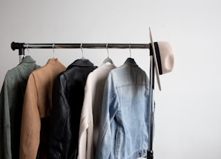 one cowboy hat and five jackets hanged on clothes rack