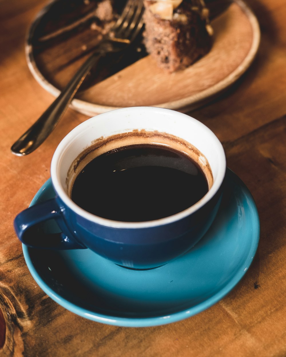 blue ceramic coffee cup on blue saucer