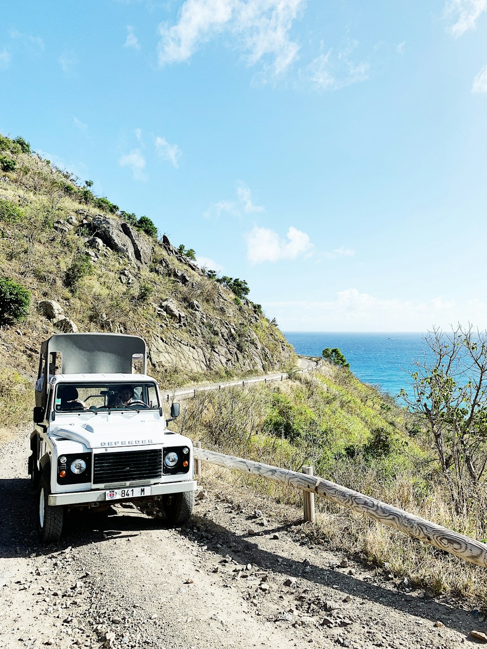 selective focus photography of vehicle traveling on dirt road during daytime